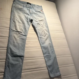 Ljusblå Replay jeans i slim fit - Snygga ljusblå jeans från Replay med klassisk femficksdesign och diskreta Replay-detaljer. Jeansen har en slim passform och raka ben, tillverkade i mjukt denimtyg som sitter skönt hela dagen. Perfekta för dig som gillar en clean och stilren look.