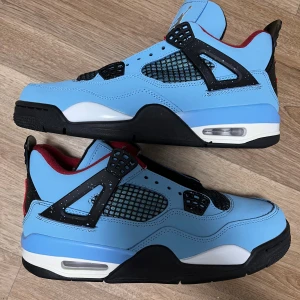 Nike Air Jordan 4 Travis Scott Cactus Jack - Säljer ett par Nike Air Jordan 4 Travis Scott Cactus Jack i ljusblå mocka med svarta och röda detaljer. Skorna har nätpaneler, svart och vit sula med röd Jumpman-logga och broderad Cactus Jack-text på hälen. Riktigt snygga sneakers med ikonisk design och coola detaljer. De är inte använda alls ! Helt nya 