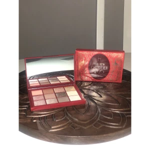 Linda Hallberg - The New Golden 20's palett - Säljer en ögonskuggspalett från Linda Hallberg, The New Golden 20's. Paletten har 12 nyanser i varma toner som guld, koppar, champagne och brunt, både matta och skimriga. Snygg röd förpackning med spegel och lyxigt art deco-mönster i guld.