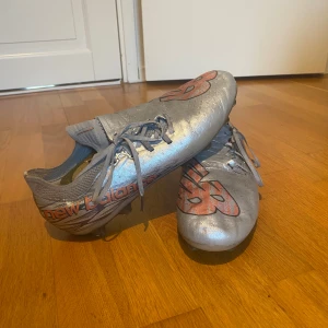 Silvriga New Balance fotbollsskor - Säljer ett par fotbollsskor från New Balance i metallic silver. Storlek 44