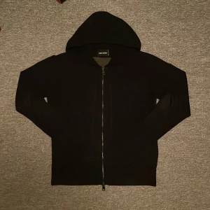 Mörkblå hoodie från Zadig & Voltaire - Mörkblå hoodie från Zadig & Voltaire i 100% bomull med dragkedja framtill och huva. På ryggen står det 'C'EST LA FAUTE À VOLTAIRE' i stora bokstäver och en dödskalle. Näst intill oanvänd, därav inga defekter. Nypris 5000kr! Pm vid frågor eller funder!