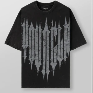 Svart oversized t-shirt YOUNGLA - Svart oversized t-shirt från YOUNGLA med stort grått grafiskt tryck framtill. T-shirten har korta ärmar, rund halsringning och en loose fit som ger en avslappnad streetwear-vibe. Tillverkad i mjuk bomull för maximal komfort.