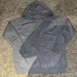 Stickad luvtröja med snörning - Säljer en klassisk stickad luvtröja. Tröjan har inget varumärke utan är bara en simpel och chill tröja. Perfekt för chill dagar eller när du vill ha något bekvämt och enkelt. Passar dig som gillar stilren och basic look.