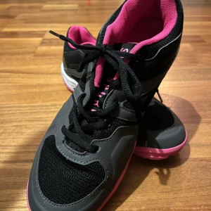 Svarta och rosa sneakers från SOC - Säljer ett par snygga sneakers från SOC i svart och grått med rosa detaljer och sula. Skorna har snörning, meshpartier för extra andningsförmåga och en cool kontrast mellan färgerna. Perfekta för dig som gillar sportig stil och vill sticka ut.