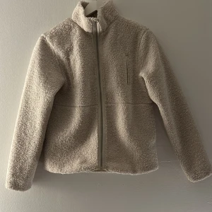 Beige teddyjacka från H&M - Mysig teddyjacka från H&M i beige färg. Sparsamt använd men i väldigt fint skick. Passar perfekt till både höst och vår!