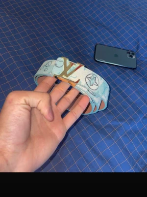 ljusblå bälte - Säljer ett ljusblått med guld. Bältet har mönster med stjärnor och cirklar, och är tillverkat i skinn med ljusblå kanter och beige insida. Perfekt för alla typer av platser. Pris kan diskuteras! PREMIUM BÄLTE ENDAST FÅ FINNS?’!