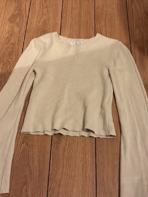 Beige tröja - En beige tröja med vida armar. 
