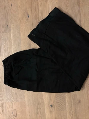 Svarta linnebyxor med resårmidja - Svarta linnebyxor med avslappnad passform och resår i midjan. Byxorna har en enkel design med fickor framtill och är gjorda i ett lätt och luftigt linnematerial. Perfekta för dig som gillar en chill och stilren look.