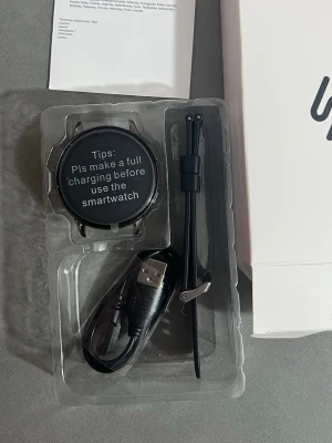 Smart Watch  - Modern smartklocka med rund färgskärm, silikonarmband och laddkabel. Klockan har flera funktioner som stegräknare och notiser. Produkten är i nyskick. Perfekt för dig som vill ha koll på hälsa och notiser direkt på handleden. Och även fin på en stilig person den är väldigt fin. 