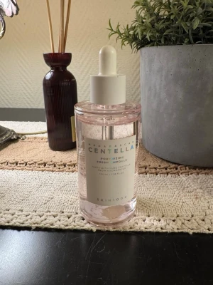 Centella ampoule från SKIN1004 - Fräsch ampoule med centella från SKIN1004, 100 ml. Kommer i en genomskinlig flaska med pipett och ljusrosa ton. Perfekt för att ge huden extra fukt och lyster, innehåller ren centella från Madagaskar.