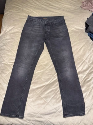  Grim Tim jeans Nudie 31-30 - Säljer ett par mörkgrå Grim Tim jeans från Nudie. Knappt använda.