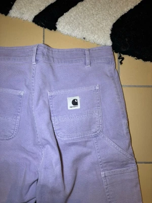 Carhartt double knee carpenter pants  - Unika lila carhatt double knee carpenters I bra skick, se bilder!  Strl 26, men måtten visar att dem sitter lite större  Midja: 76cm Längd: 106cm  Hör gärna av dig om du undrar något eller vill ha fler bilder! ✌🏻