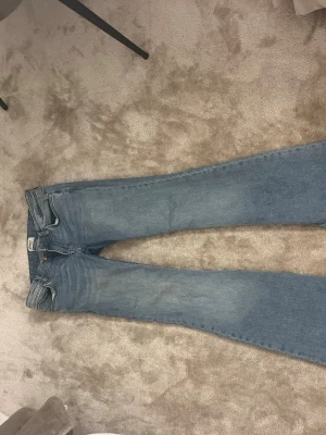 Ljusblå jeans från ONLY - Säljer ett par ljusblå jeans från ONLY med klassisk femficksdesign och normal passform. Jeansen har raka ben och är tillverkade i mjukt denimtyg med snygga slitningar. Perfekta till sneakers eller boots för en chill look. Stl 27-32