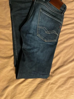 Replay Anbass mörkblå jeans slim fit - Säljer ett par Replay Anbass jeans i mörkblå tvätt slimfit W28/L32. Jeansen är i väldigt bra skick och har inga defekter👌 Modellen på bilden är 178cm och 63kg. Bara att höra av dig vid andra funderingar👑