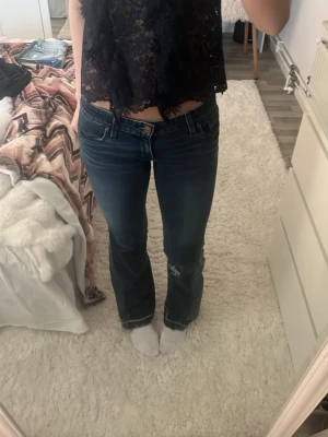 Levi's bootcut jeans mörkblå - Säljer ett par Levi's jeans i mörkblå tvätt med klassisk bootcut passform. Jeansen har låg midja, slitningar vid knät och snygga detaljer på bakfickorna. Materialet är robust denim med en skön känsla och tydliga kontrastsömmar. Skit bra sytt om jag får säga det själv 💗