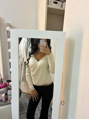 Beige omlott ribbad tröja - Säljer en beige ribbad tröja med omlott-design och v-ringad hals. 