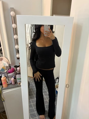 Svart ribbad långärmad topp - Säljer en svart långärmad topp med fyrkantig urringning och ribbad struktur. 