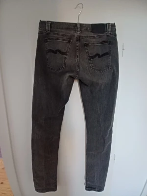 Svarta jeans från Nudie Jeans - Ett par riktigt feta grå svarta Nudie jeans med tvättning  Säljer de nu för att de sitter lite tajt i midjan men annars är det inga skavanker på de  En lite tajtare passform som sitter riktigt snyggt  Pris kan diskuteras tveka inte på att höra av er