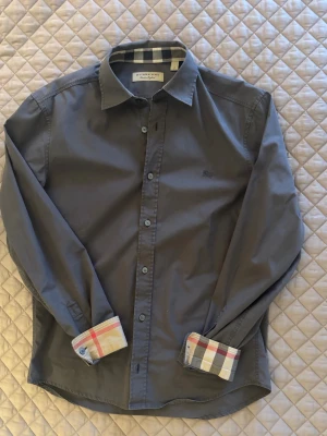 Burberry skjorta - Säljer denna riktigt feta burberry skjortan! | Väldigt bra skick. | Äkta. | Fett mörkgrå färg. | Riktigt bekväm. | Storlek S. | Släng iväg en signal vid funderingar så svarar jag snabbt. |