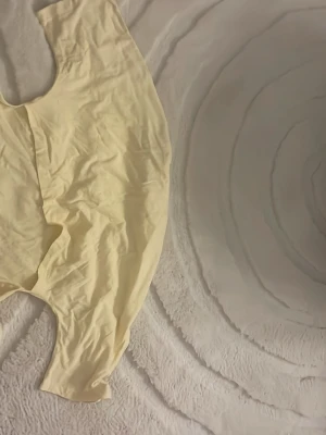 Gul t-shirt med snörning från Nelly - Säljer en ljusgul t-shirt från Kelly med korta ärmar och rund hals. T-shirten har långa snören på sidorna som kan knytas för en cool detalj. Materialet är mjukt och känns som bomull, perfekt för vår och sommar. Enkel och fräsch design som passar till jeans eller kjol.