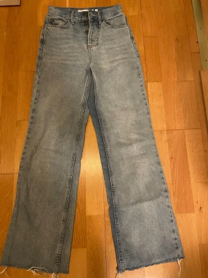 Subdued high rise straight jeans - Ljusblå jeans från Subdued med hög midja och raka ben. Jeansen har råa, fransiga benslut och klassisk femficksdesign. Tillverkade i jeansmaterial med knappgylf och subtilt tvättad look för en chill vibe. Storlek 30 eller xs, innerbenslängden är 74cm, midjan 31.