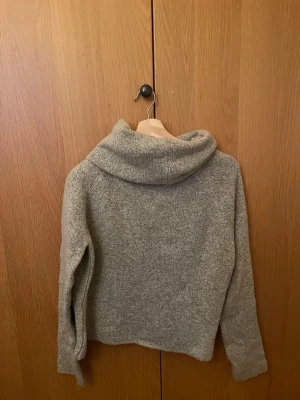 Grå stickad tröja från Chiquelle  - Mysig grå tröja, lite polo-likt, och långärmad design. Tröjan är stickad och har en loose passform som ger en chill vibe. Perfekt för kyliga dagar när du vill vara både bekväm och snygg. Den är verkligen supervarm - rekommenderar!! Var one size från Chiquelle (passar en S/M).