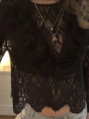 Svart spetsblus med volang - Supersnygg svart blus från Zara i spets med detaljerad broderad design och volang framtill 💕
