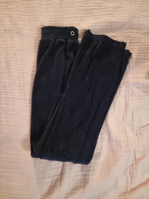 Svarta mjukisbyxor i sammet - Mysiga svarta mjukisbyxor i mjuk sammet med resår i midjan. Perfekta för chill dagar hemma eller när du vill ha det extra bekvämt. Klassisk rak passform och enkel design utan synliga loggor eller detaljer.