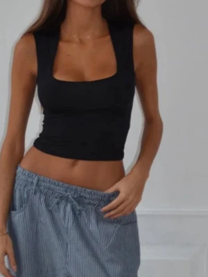 Svart croppad linnetopp med breda axelband - Aldrig använd med prislapp kvar. Storleken på hemsidan är xs/s