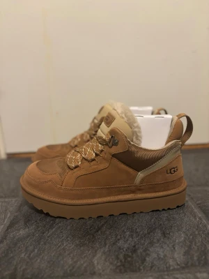 UGG Lowmel - Säljer ett par splitternya bruna UGG Lowmels med snörning och fluffigt foder. Perfekta för kalla dagar och riktigt snygga till jeans. Bara skriva vid intresse