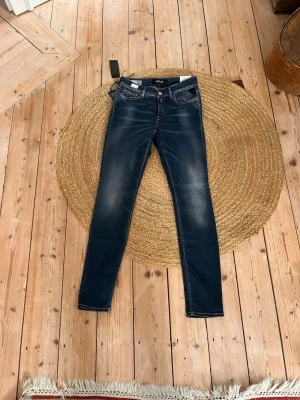 Replay Hyperflex X-Lite skinny jeans - Säljer ett par mörkblå Replay Hyperflex X-Lite jeans i skinny fit. De har klassisk femficksdesign, snygga slitningar och stretchigt material för extra komfort. Perfekta om du gillar tajta jeans med modern look och cool tvätt.