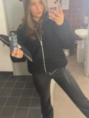 Svarta bootcut byxor i skinnimitation - Snygga svarta byxor från Gina young i läderimitation som är bootcut och  lågmidja står de på hemsidan. Byxorna har dragkedja framtill och bälteshällor och midjemått rakt över är 34,5 cm och innerbenslängd är 75 cm. Hör av dig vid frågor eller intresse 💗