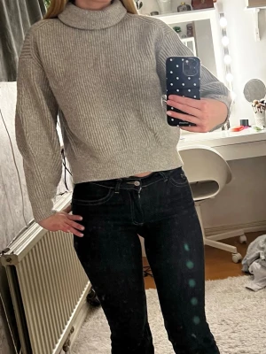 Grå ribbad polotröja från H&M XS - Säljer en grå ribbad polotröja från H&M i storlek XS. Tröjan har hög krage, lång ärm. Materialet är en mjuk mix av akryl, polyamid och ull som gör den både varm och skön. Perfekt till höst och vinter!
