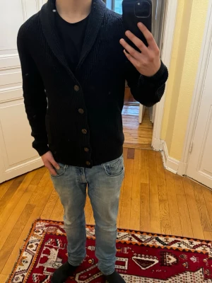 Svart stickad kofta med knappar - Säljer just nu denna feta koftan i storlek S och passar även M. Tröjan är i mycket bra skick med inga defekter alls. Tveka inte att höra av er vid frågor och funderingar!🙌