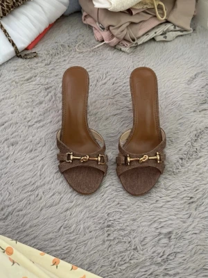 Bruna klackskor - Jättefina helt oanvända bruna klackskor med en guld detalj! Jättefina och passar perfekt till ett par snygga jeans. De är i storlek 39 och är väldigt sköna!