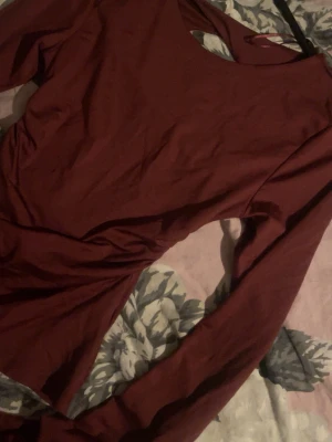 Vinröd långärmad topp - Säljer en vinröd långärmad topp med öppen rygg. Toppen har en tight passform och är tillverkad i ett mjukt stretchigt material, perfekt att styla med jeans eller kjol.