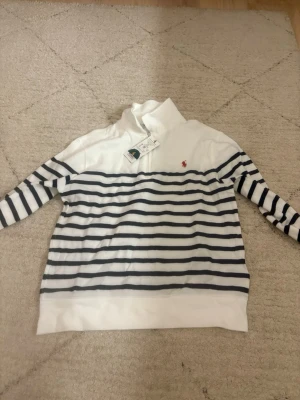 Randig tröja från Polo Ralph Lauren - Vit och marinblå randig tröja från Polo Ralph Lauren.  Storlek 140.
