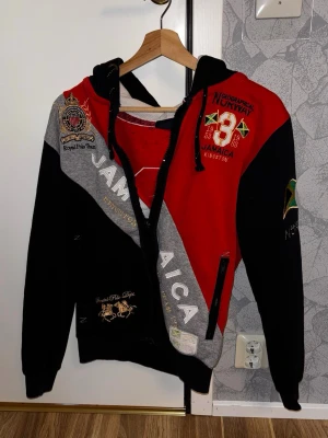 Geographical Norway Hoodie - Geographical Norway Hoodie med jamaicansk design. Passar XS-S