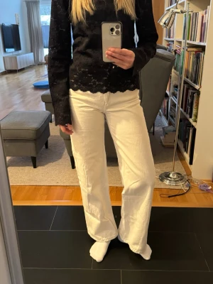 Vita wide jeans från Monki - Säljer ett par krämvita jeans från Monki med mid waist och raka, breda ben. Klassisk femficksmodell med bälteshällor och knappgylf. Materialet är kraftig bomull som ger en snygg och avslappnad look. Perfekta till sneakers eller boots nu till våren.