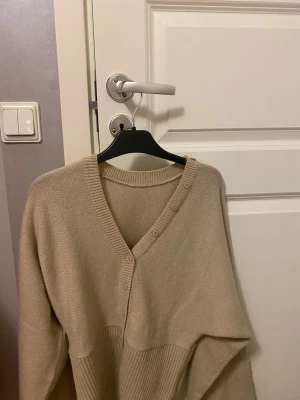 Beige kofta med v-ringning och knappar - Mysig beige kofta med v-ringad hals och knappar framtill. Aldrig använd köptes igår 