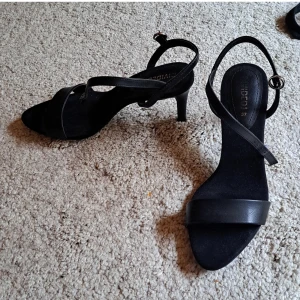 Klackskor  - Säljer dessa trendiga klackskor för 99 kr. Stl 37, märke divided, knappt använda. Färgen är svart så passar till många outfits. Varken för låga eller höga- perfekta för fest. (pga banden där bak ej placerad längst bak)