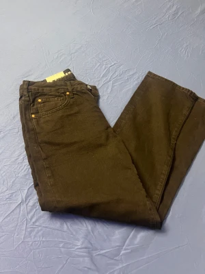 Svarta straight jeans från MINGO - Svarta jeans från MINGO i rak modell med låg midja. Klassisk femficksdesign, kopparfärgade nitar och tydlig etikett i midjan. Jeansen är tillverkade i bomull och har en stilren look som passar till det mesta.