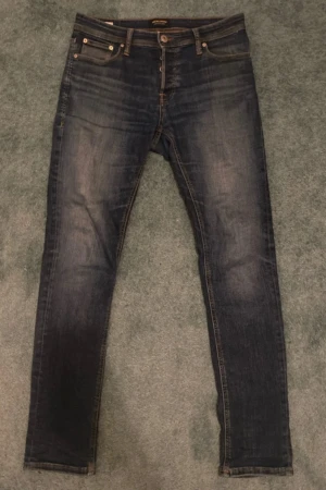 Mörkblå slim jeans från Jack & Jones - Snygga mörkblå jeans från Jack & Jones med slimfit passform och klassisk femficksdesign. Perfekt för dig som gillar en smal siluett och stilren look. Köp en bundle så kan priset diskuteras, om du har några frågor tveka inte på att ställa de. 