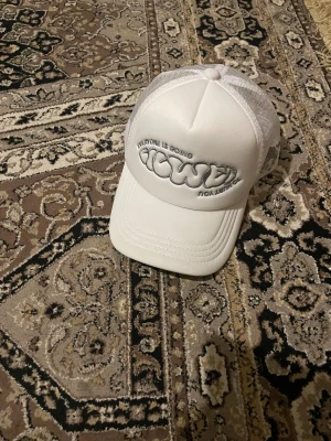 Vit meshkeps med broderad text - Snygg vit keps med mesh på sidorna och bak, samt broderad text framtill i silver. Framsidan har en cool 3D-brodyr med texten 'Everyone is going Faded'. Perfekt för dig som gillar streetwear och vill sticka ut med en unik keps.