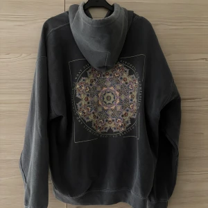 Mörkgrå vintage hoodie  - Mörkgrå vintage hoodie, urtvättad färg med större print på ryggen och mindre tryck framtill. Mer åt en loose fit på hoodien. Väldigt gott skick.