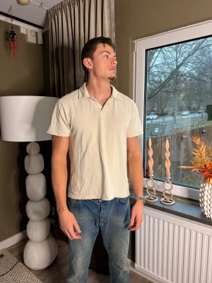Beige kortärmad t-shirt med krage från solid  - Snygg beige t-shirt med klassisk krage och korta ärmar från solid. Modellen är rak och har en enkel, stilren look som passar till jeans eller shorts. Materialet är mjukt och känns skönt mot huden, perfekt för dig som gillar en clean och avslappnad stil.