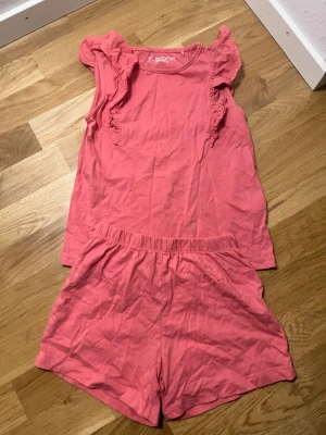 Rosa shorts med resår från Moving Waves - Säljer ett par mjuka rosa shorts från Moving Waves med elastisk midja för skön passform. Materialet är bomull och färgen är en härlig ljusrosa ton. Perfekta för varma sommardagar eller som chill-plagg hemma.