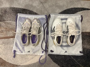 Adidas F50 elite and copa pure III elite Road to glory colorway - Två par Adidas fotbollsskor säljes! F50-modellen har en vit och gul färg med svarta ränder och lila detaljer, samt snörning och platt sula med dobbar. Copa Pure III är vita med svarta ränder och guldiga sulor, också med snörning och dobbar. Båda paren är snygga och perfekta för fotbollsplanen. F50 is size 40 2/3 and copa is size 40 