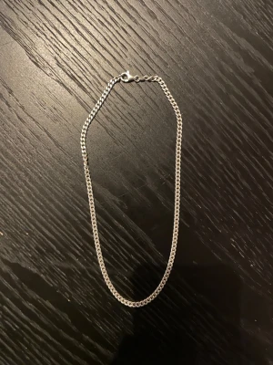 Kedjehalsband i äkta silver - Stilrent halsband i äkta silver med klassisk pansarlänk och karbinhake. Perfekt för dig som gillar minimalistiska smycken med lite edge. Märkt 925 för äkta silver. Passar både ensam eller i lager på lager-stil.