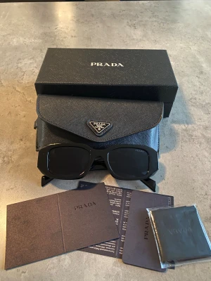 Prada Solglasögon  - Helt nya Svarta par Prada solglasögon som följer med alla tillbehör som finns med i bilden. För mer frågor så finns jag 🙂🙂🙂
